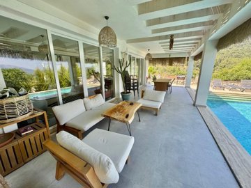 Upscale Detached Villa In Fethiye For Sale - Poolside terrace offering shade and seating